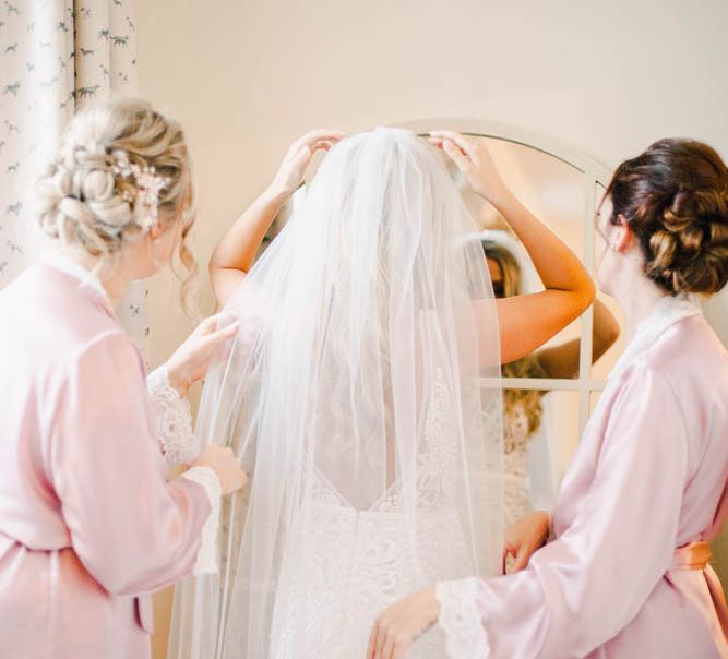 Bride on wedding morning putting her veil on 