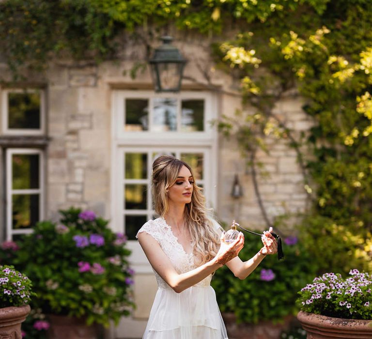 Bride in lace getting ready robes putting on perfume 