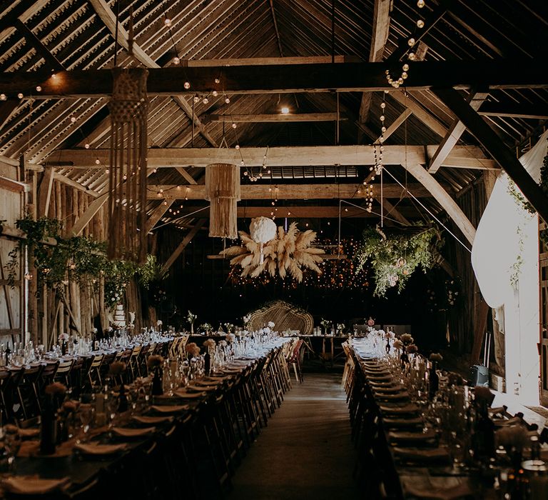 Rustic barn reception with fairy lights, wicker chair and macrame rustic wedding decor 