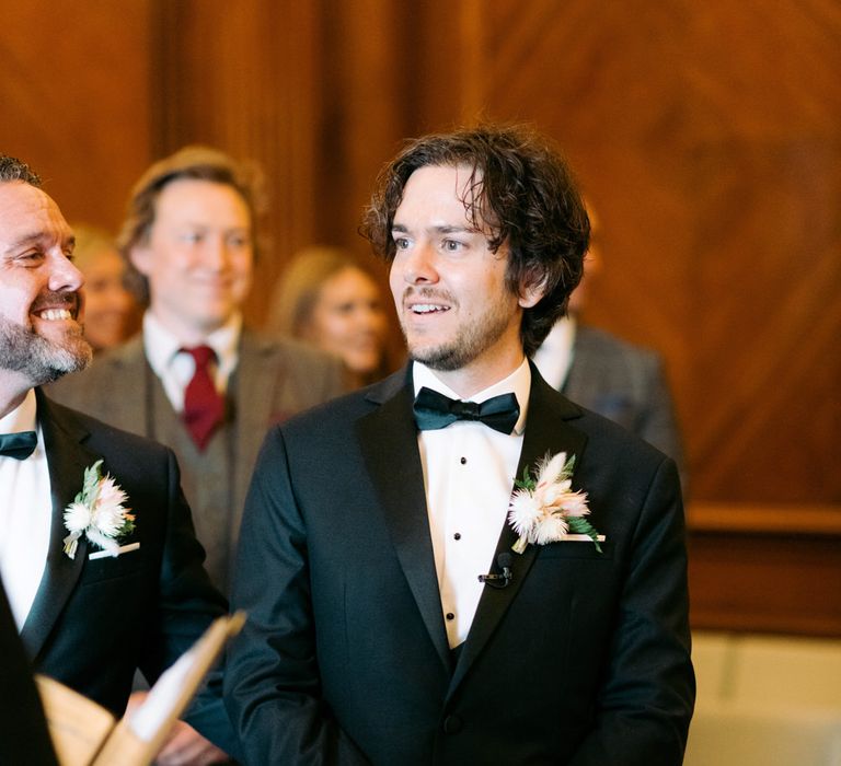 Groom waiting for the bride to be wearing buttonhole King Protrea flower