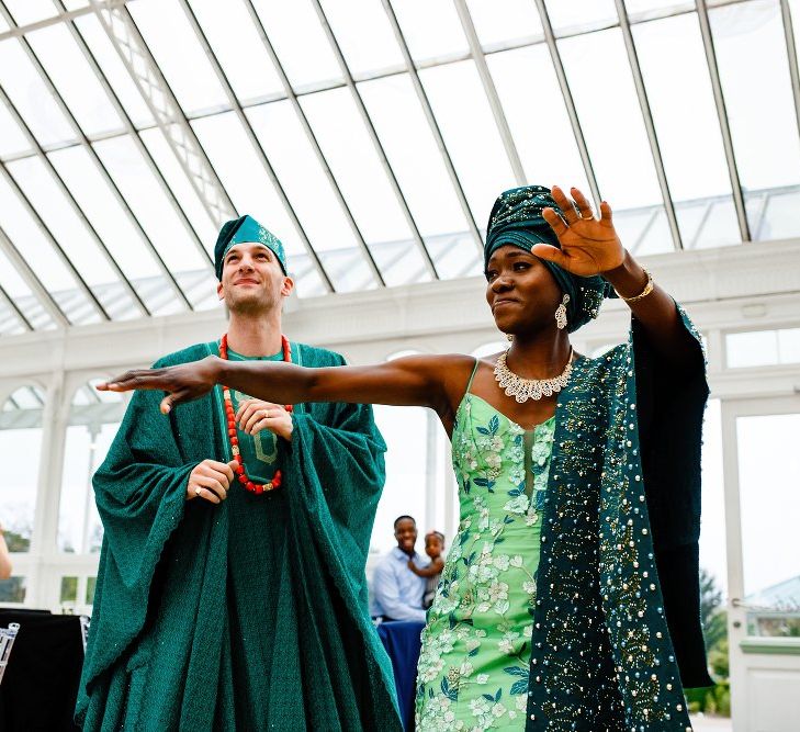 Bride and groom money dance entrance in green Nigerian outfits 