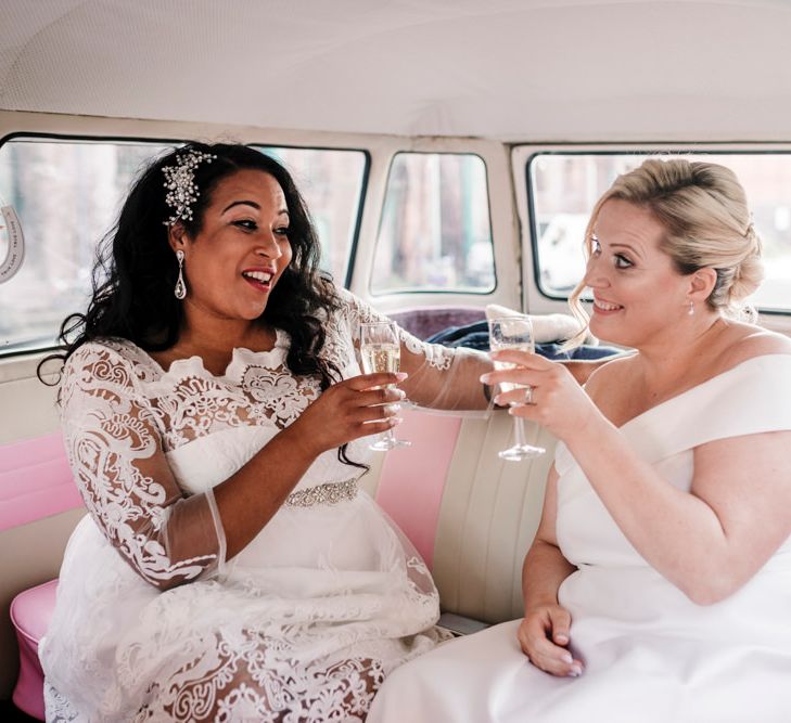 Newly-wed brides enjoying Champagne in pink and white camper van at Liverpool wedding 