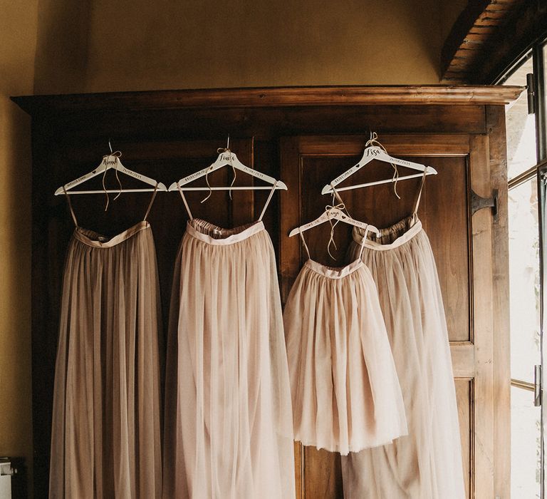 Neutral pink toned tulle bridesmaids skirts hanging up