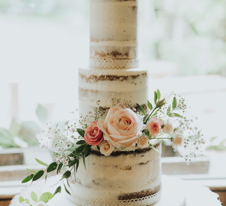 Semi-naked, three tier wedding cake with flower decor