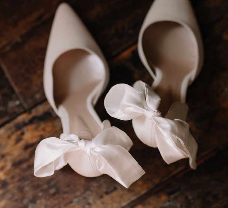 Neutral toned pointed wedding shoes with bow to the back