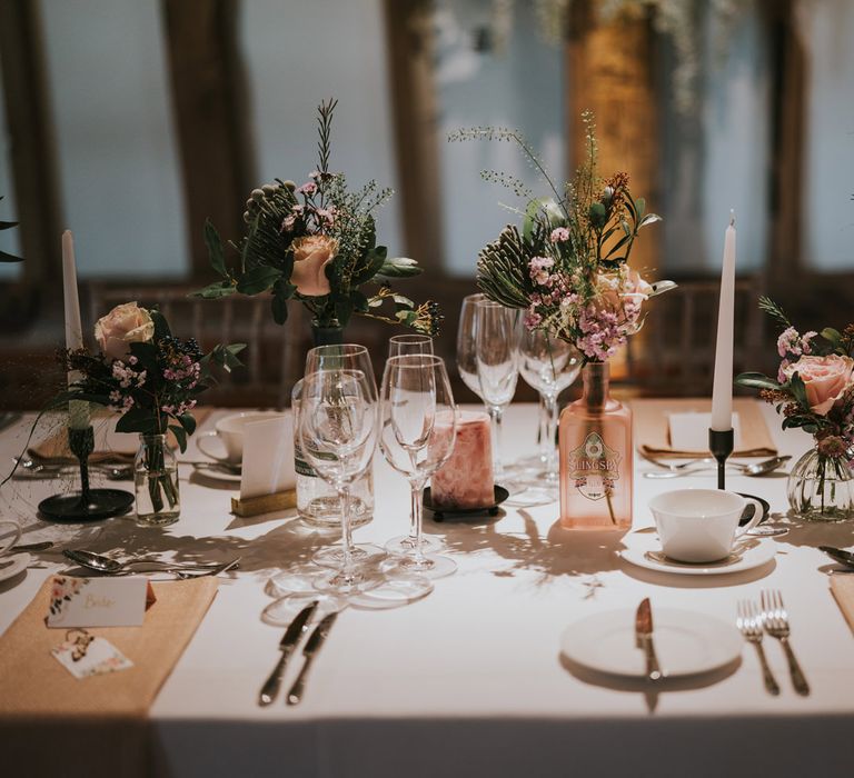 Table decor featuring gin bottles with floral decor