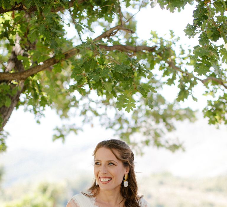 The bride standing under a tree in the Greek countryside