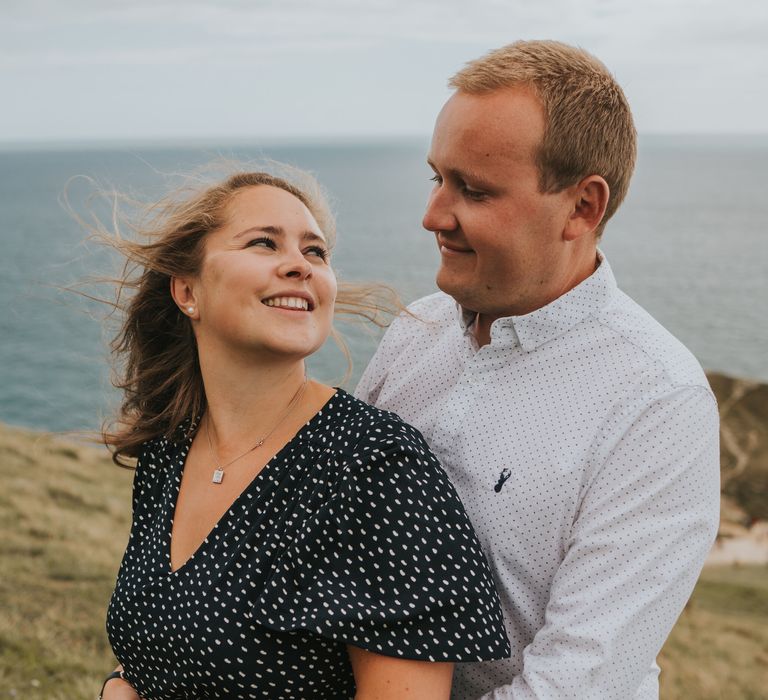 Groom to be holding his fiancé for beach engagement photography