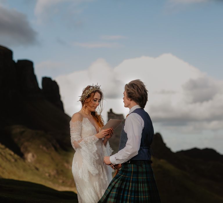 Bride & groom stand on the hillside with blue skies in the background