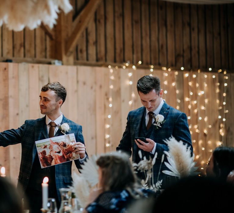 Best men delivering their wedding speech at The Barns reception holding a chicken picture 