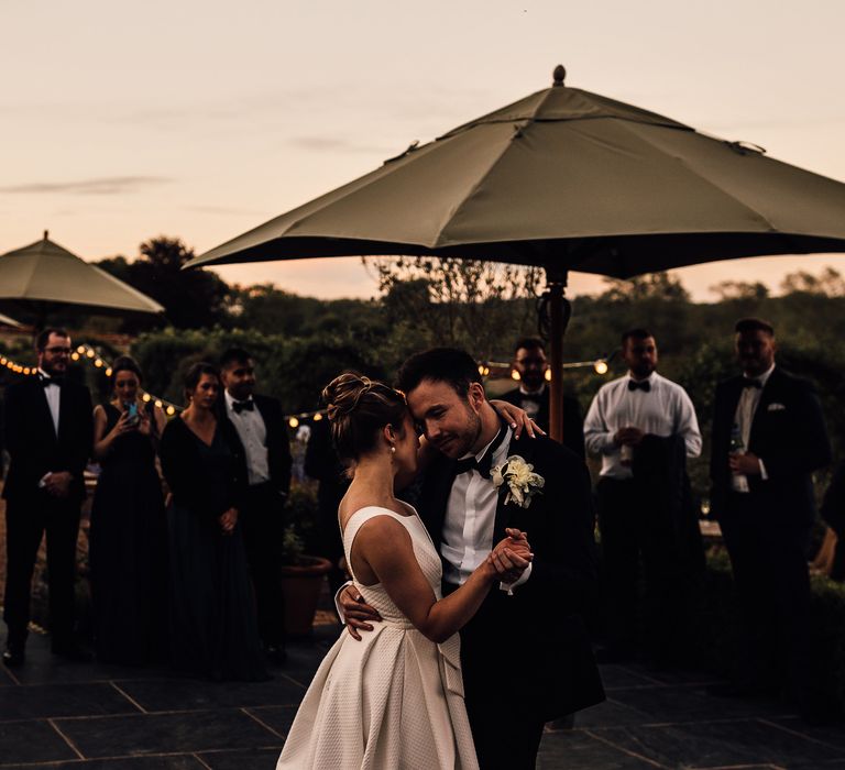 Bride & groom hold one another outdoors on their wedding day