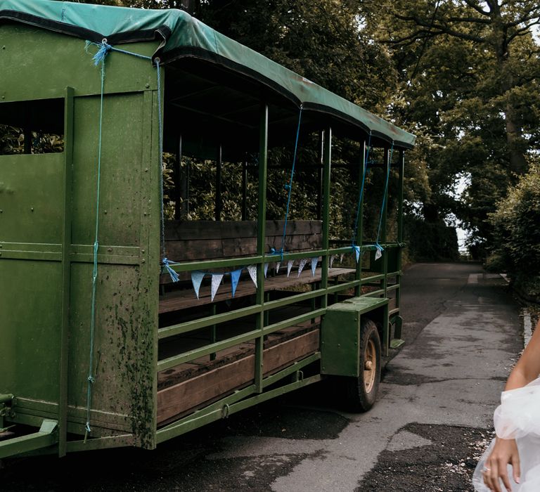 Green tractor to take bride and her bridesmaids to wedding ceremony for farm wedding