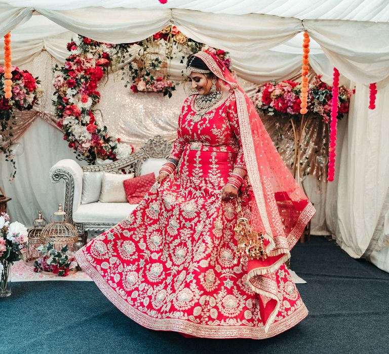 Bride spins around wearing traditional Lengha on the day of her wedding in marquee 