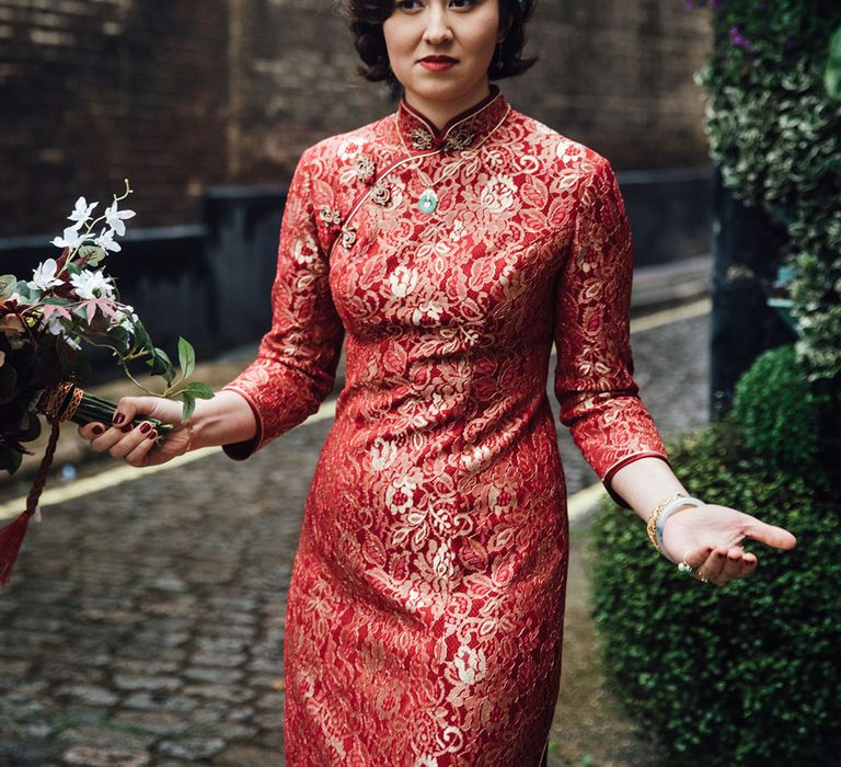 Bride wears red lipstick with her red dress and short styled hair