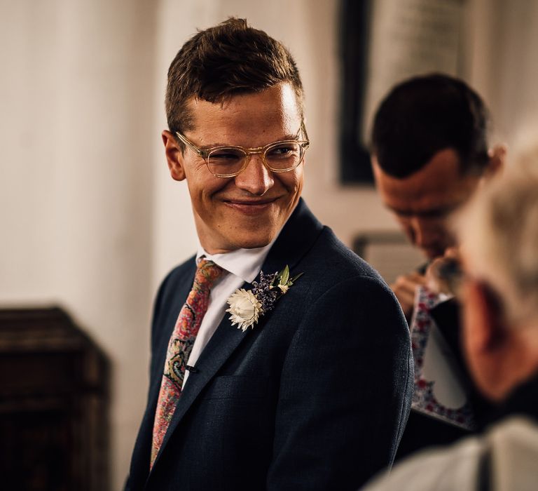 Groom in navy wedding suit and patterned tie for church wedding