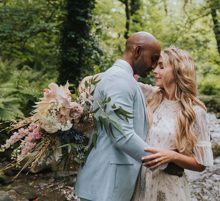 Bride & groom touch their foreheads together as they close their eyes and smile