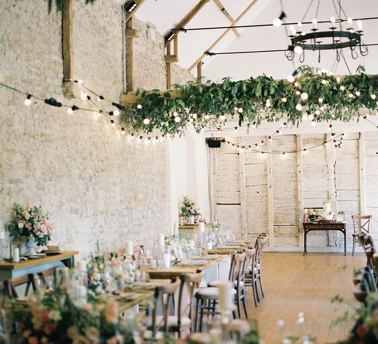 Barn wedding reception with foliage and festoon light wedding decor 