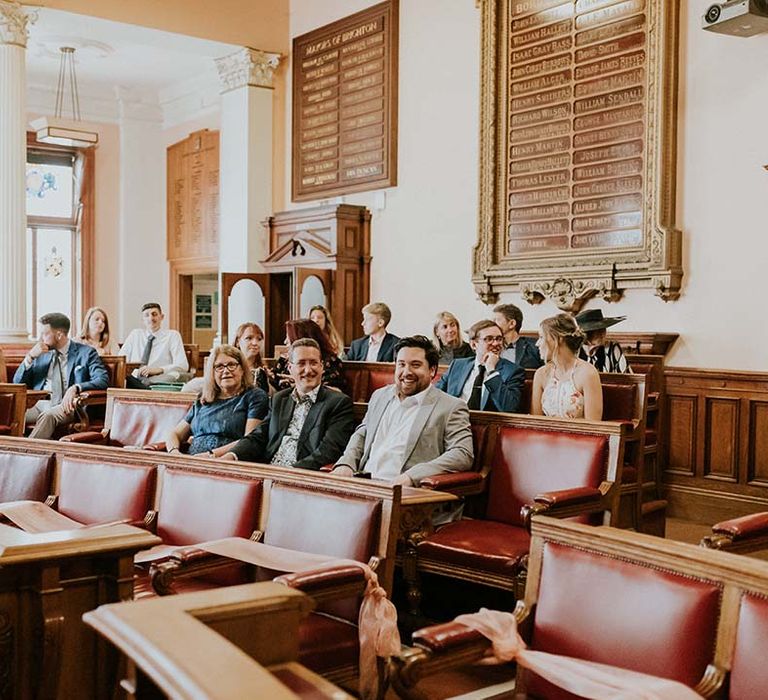 Wedding guests await bride & groom during ceremony