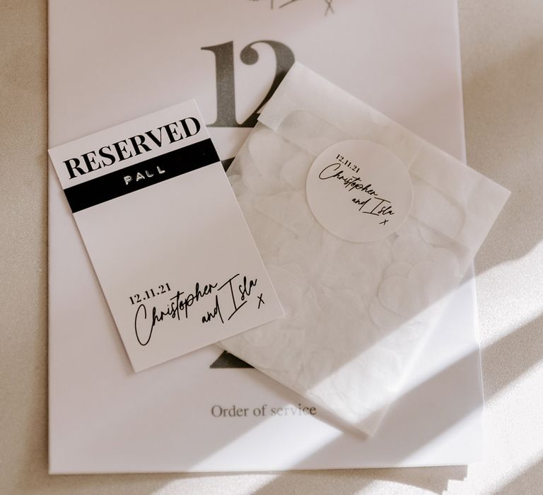 Monochrome wedding stationery with Reserved label, confetti bag and order of the day. 