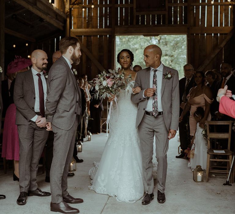 Bride walks down the aisle to meet her groom during ceremony