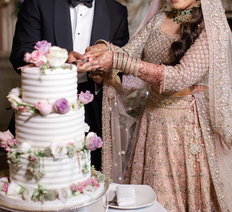 Bride & groom happily cut their wedding cake during reception