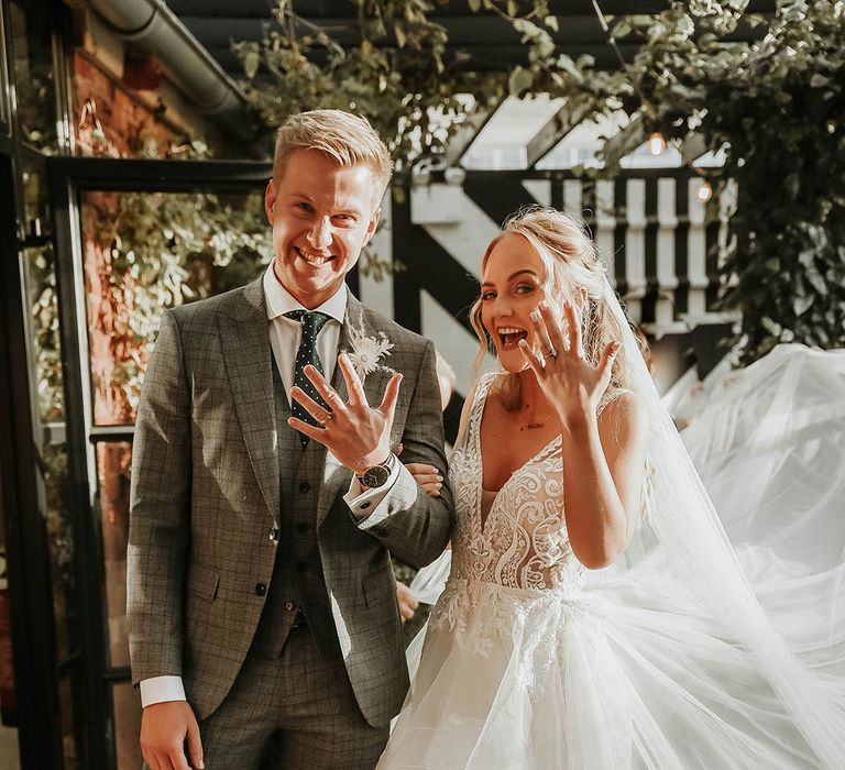 Bride in Eleganzza Sposa wedding dress and groom flash their wedding rings after civil ceremony