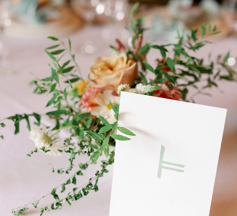 Green and white wedding stationery with orange roses and green flower arrangement 