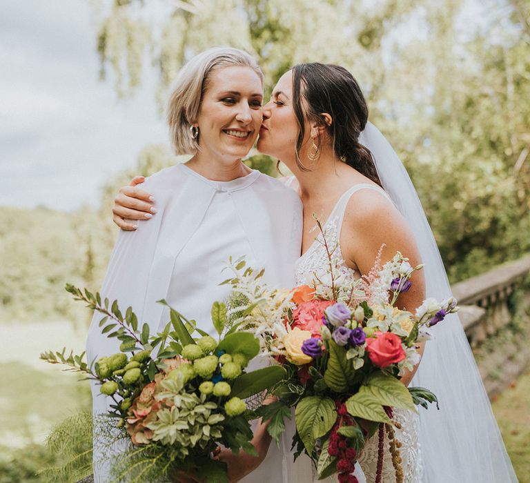 Bride in lace Made With Love bridal dress kisses bride in handmade jumpsuit with cape