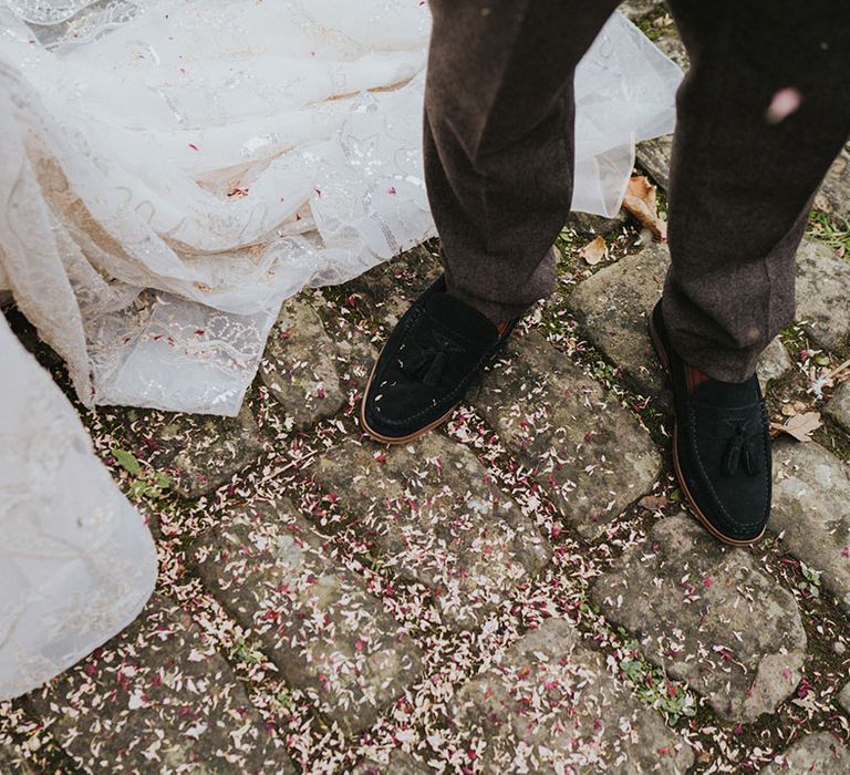 Groom's suede tassel shoes with confetti on the ground after being thrown in celebration for the couple