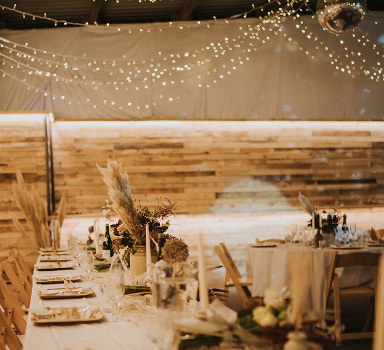 Table settings with white tablecloths, napkkins and candles with pampas grass 