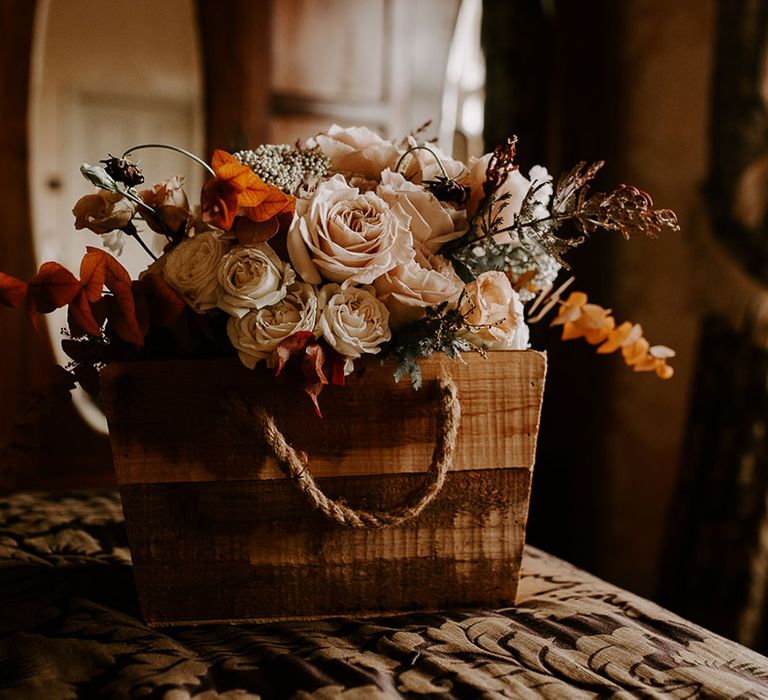 Orange, white and pink wedding bouquet in wooden box with rope handles 