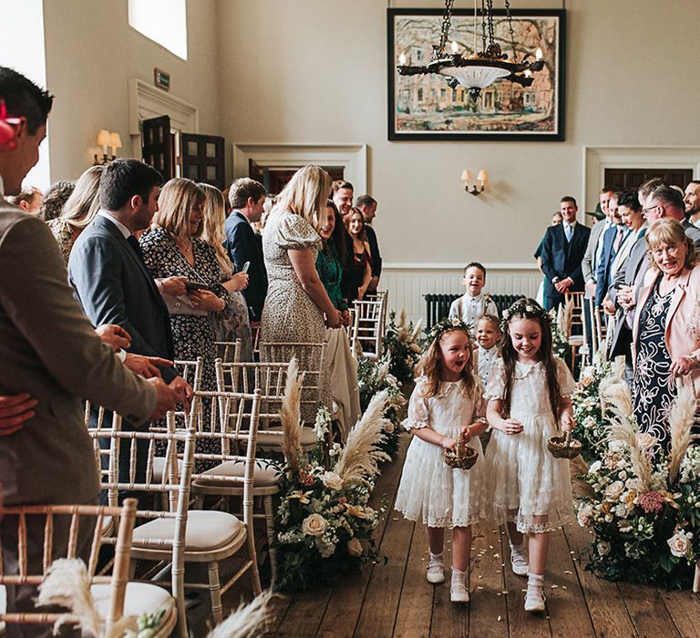 Flower girls in white frill Polka dot dresses throw petals 