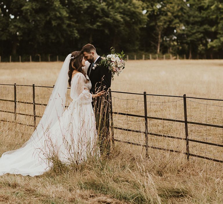 Bride and groom rest their foreheads against each other for a cute couple portrait 