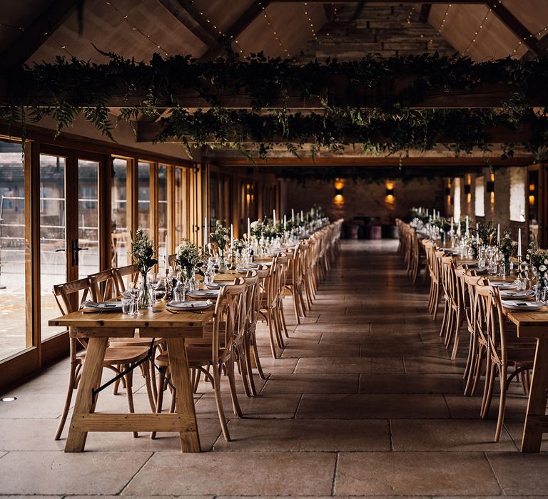 Old Gore Barn rustic wedding venue with green foliage and tables made with a classic green and white wedding tablescape 