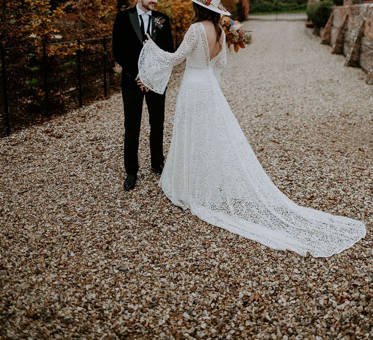 Groom in velvet green tuxedo with the bride in a lace wedding dress with a train 