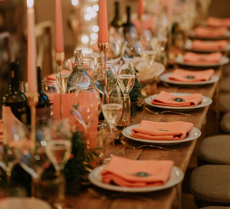 Reception room of Marylebone Town Hall with silver and gold wedding streamers, orange tapered candles, orange napkins, orange rose and foliage tablerunners and fairy lights 