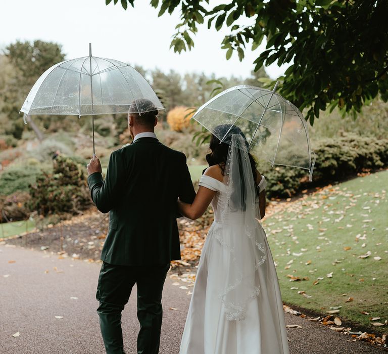 Bride in fingertip length lace edge veil walks alongside her groom at the Royal Botanic Garden Edinburgh