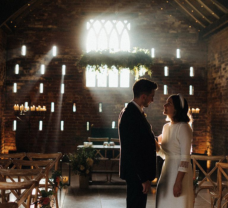 Grangefields wedding venue with light streaming in through the windows with the bride in a high neck wedding dress and groom in three piece suit for rustic wedding 