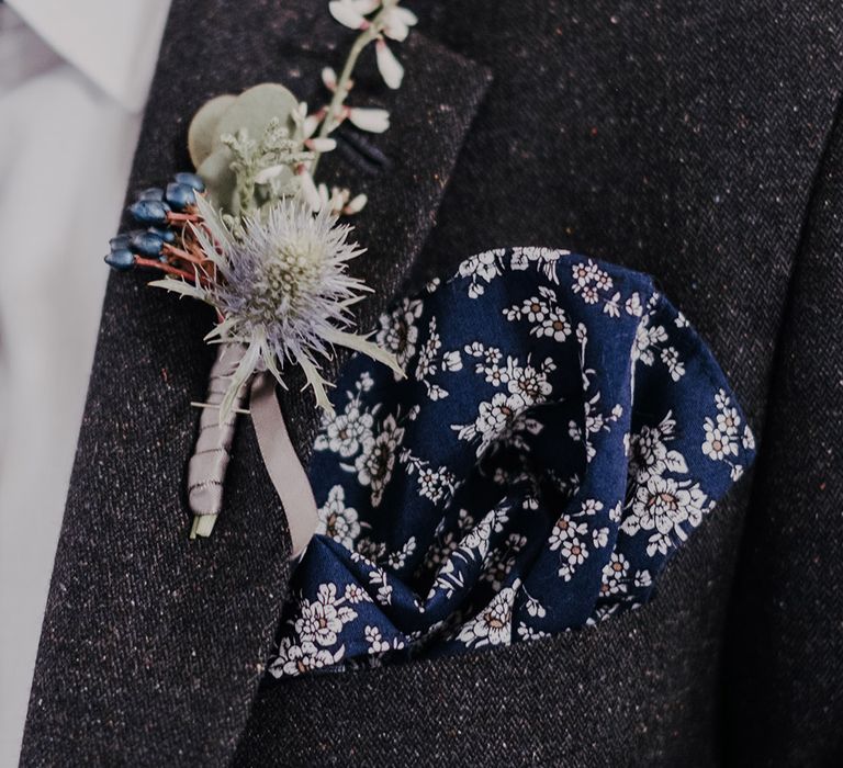 Groom in dark suit with blue and white flowers with thistle buttonhole 