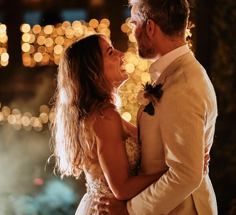 Bride and groom share first dance under festoon lighting at Italian villa destination wedding