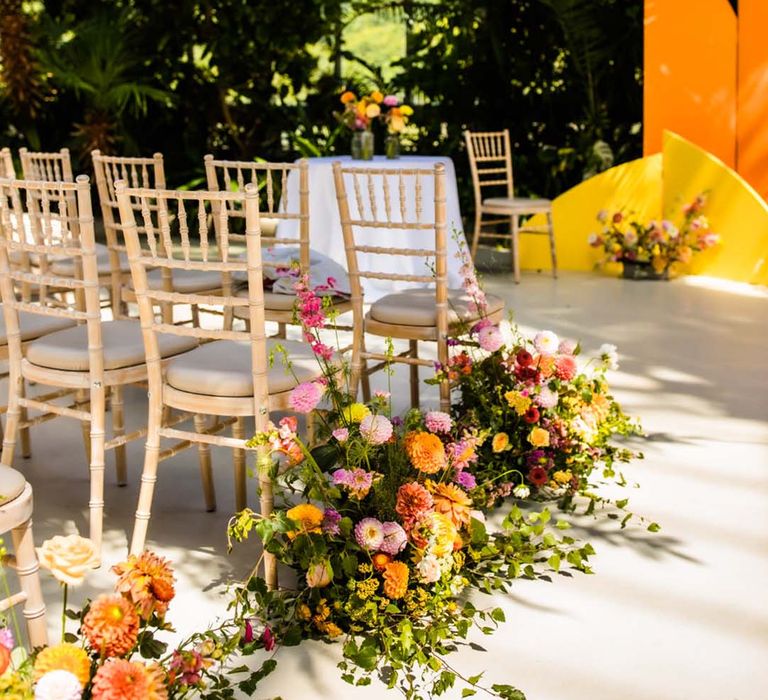 Colourful vibrant wedding aisle flowers with roses and dahlias for citrus colour scheme wedding 