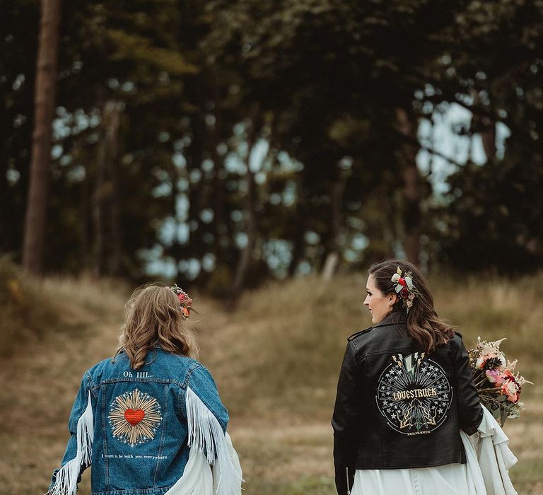 Lesbian wedding with the bride in a denim jacket with a custom motif based on her favourite song with bride in leather jacket with similar motif design