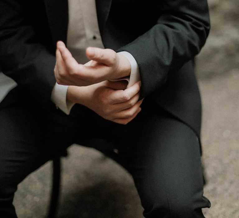 Groom in black tuxedo with red rose buttonhole for traditional and luxury wedding 