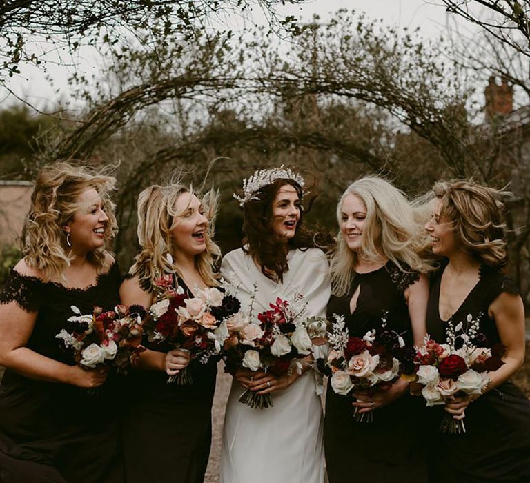 Bride with sparkly crown hair accessory with the bridesmaids in black gowns 