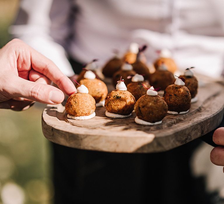 Wedding canapés are handed out at the classic country house wedding 