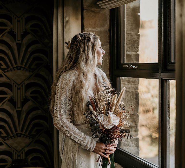 Bride in white blonde wavy hair wearing long sleeve lace wedding dress 