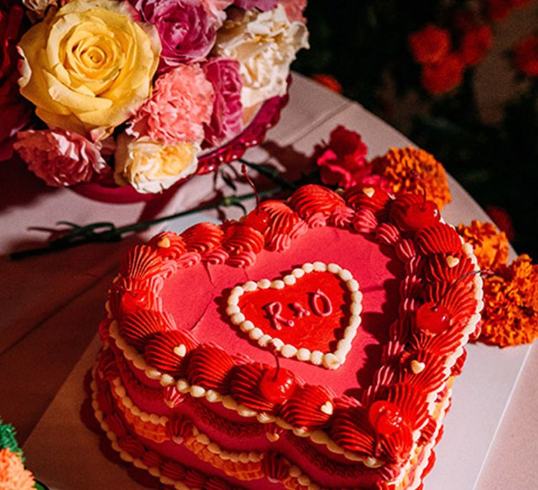 Hot pink heart shaped retro wedding cake with cherries and mini love hearts 