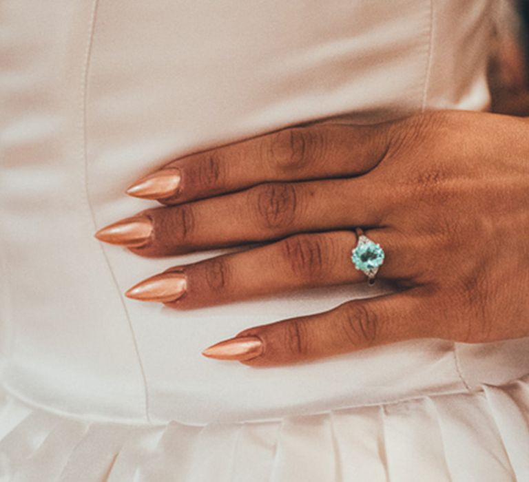 Bride with long pointed nails in apricot orange chrome shade for wedding nails 