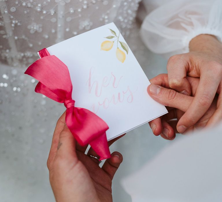 Lemon pattern on wedding vow booklet tied with hot pink ribbon 