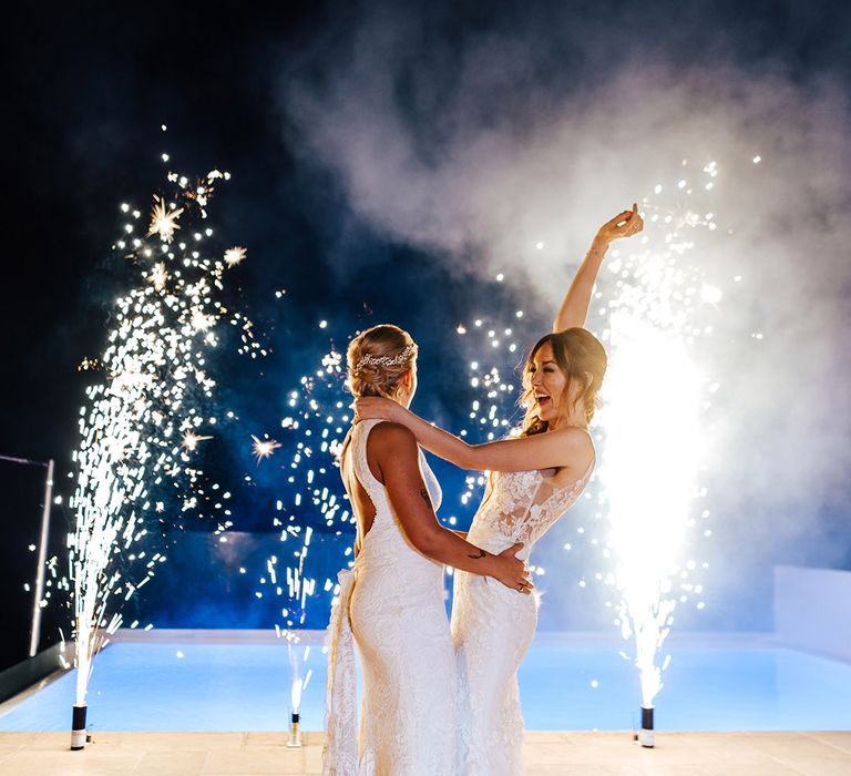 Brides celebrate their wedding day by the pool with fireworks 